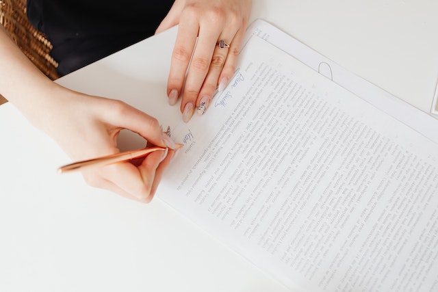 person signing a lease document with a gold pen